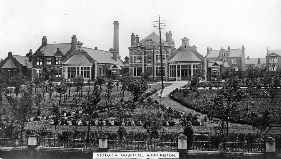 Historic black‑and‑white photograph of Victoria Hospital in Accrington, showing multiple large brick buildings and landscaped gardens.